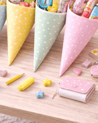 Schultueten gefüllt, daneben Ideen zum Befüllen zB Stifte, Geldbörse, Armbanduhr für Kind